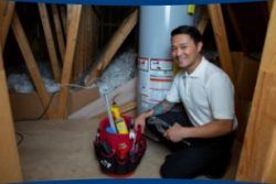 Christian Brothers employee in front of a water heater